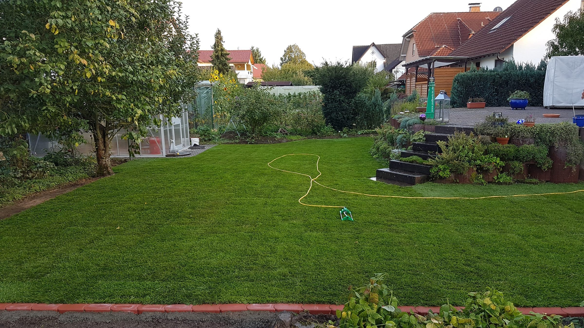 Gepflegter Privatgarten mit Rasenfläche, Beeten und Terrasse